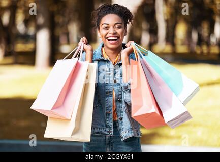 Mujer negra de compras y bolsos para pensar y comprar lujo en la sonrisa de  la ciudad y el cliente mujer afroamericana y compradora con ropa boutique marcas  caras y al aire