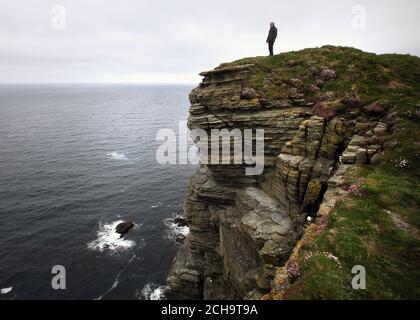Los visitantes caminan a lo largo de las cimas del acantilado sobre el mar En Marwick Head en Orkney