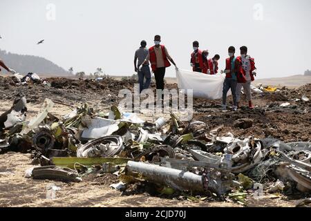 Los trabajadores de la Cruz Roja Etíope llevan una bolsa con los restos de las víctimas de un accidente aéreo del Vuelo ET 302 de Ethiopian Airlines en el lugar de un accidente aéreo, cerca de la ciudad de Bishoftu, al sureste de Addis Abeba, Etiopía, 12 de marzo de 2019. REUTERS/Baz Ratner