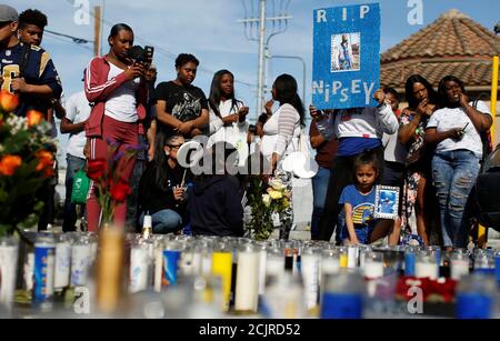 La gente se reúne en torno a un monumento makeshlift para el rapero Nipsey que fue asesinado a tiros fuera de su tienda de ropa en los Ángeles, California, EE.UU., 1 de abril de 2019. REUTERS/Mario Anzuoni