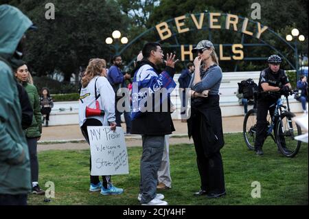 Melanie Chapman (R) habla con Danny Rodríguez (C), un partidario de Trump, en una protesta contra Trump en un parque a pocos kilómetros de una comunidad cerrada donde el presidente estadounidense Donald Trump está llevando a cabo una recaudación de fondos en Beverly Hills, California, EE.UU. El 13 de marzo de 2018. REUTERS/Andrew Cullen