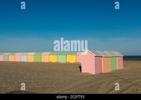 Cabañas de playa multicolores alineadas en la playa desierta de Berck en Francia Foto de stock