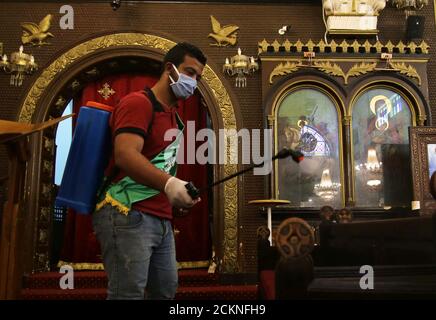 Un voluntario que lleva una máscara pulveriza desinfectante dentro de una iglesia cuando Egipto cierra iglesias y mezquitas debido a la propagación de la enfermedad del coronavirus (COVID-19), en el Cairo, Egipto 4 de abril de 2020. Foto tomada el 4 de abril de 2020. REUTERS/Hanaa Habib