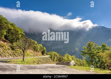 Campo francés. Pequeño camino de montaña en el camino a los pasos en Vercors con formaciones de nubes. Foto de stock