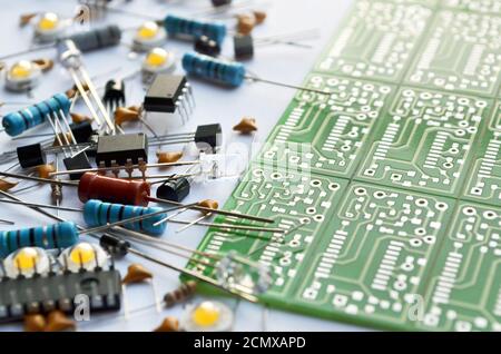 Distintos componentes electrónicos y primer plano de la placa de circuitos electrónicos verde. Profundidad de campo reducida, enfoque selectivo Foto de stock