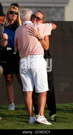 La tenista danesa Caroline Wozniacki (volver) abraza a su novio el golfista del norte de Irlanda Rory McIlroy, el padre Gerry después de la cuarta y última ronda del Campeonato Mundial DP Tour en Jumeirah Golf Estates en Dubai el 25 de noviembre de 2012. El número uno del mundo McIlroy recogió $2.33 millones de valor del tesoro del desierto después de rechazar un cargo récord del compañero del equipo de Ryder Cup Justin Rose para ganar el Campeonato Mundial del DP del Tour el domingo. REUTERS/Jumana el Heloueh (EMIRATOS ÁRABES UNIDOS - Tags: DEPORTE GOLF TENIS)