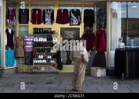 Un hombre se encuentra a una tienda de ropa económica en el centro de la ciudad siderúrgica de Eisenhuettenstadt, 124 km (77 millas) al este de Berlín el 26 de