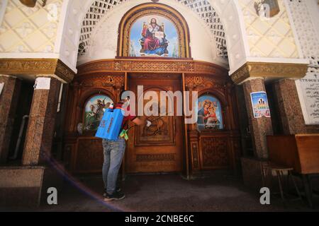 Un voluntario que lleva una máscara pulveriza desinfectante frente a una iglesia cuando Egipto cierra iglesias y mezquitas debido a la propagación de la enfermedad de coronavirus (COVID-19), en el Cairo, Egipto 4 de abril de 2020. Foto tomada el 4 de abril de 2020. REUTERS/Hanaa Habib