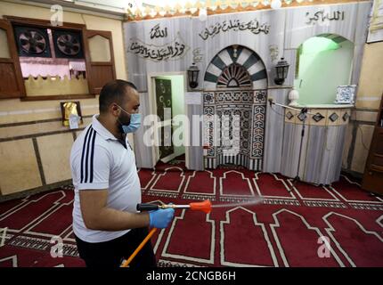 Un voluntario que lleva una máscara pulveriza desinfectante dentro de una mezquita, ya que está preparado para la oración después de ser reabierto, después del brote de la enfermedad del coronavirus (COVID-19), en el Cairo, Egipto, 26 de junio de 2020. REUTERS/Mohamed Abd el Ghany