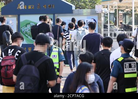 Seúl, Corea del Sur. 19 de septiembre de 2020. Los solicitantes de la prueba de reclutamiento policial para el examen de reclutamiento policial ingresan al sitio de la prueba escrita en una escuela en Seúl el 19 de septiembre de 2020. Crédito: Yonhap/Newcom/Alamy Live News