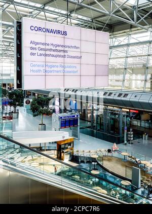 Sala de salida vacía en el aeropuerto de Düsseldorf en tiempos de la pandemia de corona, una exposición proporciona información sobre las normas de higiene de la Salud Foto de stock