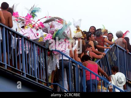 Con sus trajes, los juerguistas del carnaval se mezclan con los viajeros que llegan al estadio Sambódromo, en Río de Janeiro, 11 de febrero de 2002. Las fiestas de Carnaval en todo Brasil se celebran hasta el 12 de febrero. REUTERS/Sergio Moraes SM/SV