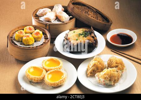 Comida asiática variada dim sum en vaporera de bambú Foto de stock