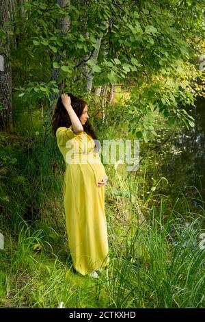 alto He aprendido judío Mujer embarazada con vestido amarillo en la naturaleza Fotografía de stock  - Alamy