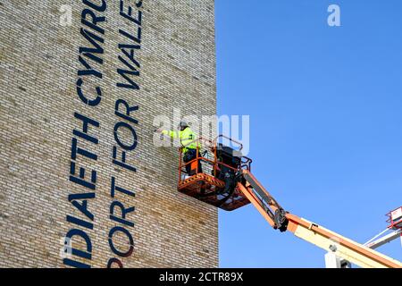 Pontypridd, Gales – Septiembre de 2020: Un trabajador en la cuna de un ascensor hidráulico de la cereza fuera de un nuevo bloque de oficinas en el centro de la ciudad de Pontypridd Foto de stock