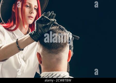Peluquería en guantes haciendo un corte de pelo. Visita a la peluquería Foto de stock