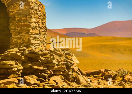 Vista exterior de la construcción de un refugio de piedra en un paisaje árido, provincia de la rioja, argentina Foto de stock