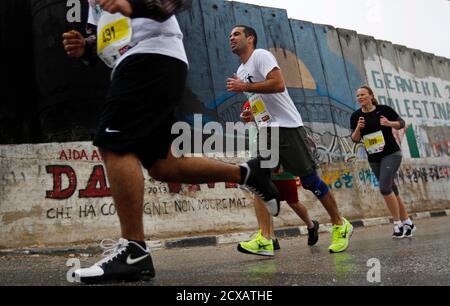 Participants Run Past The Controversial Israeli Barrier During A Marathon In The West Bank Town Of Bethlehem April 21 13 While Half Of The Participants In Sunday S Event Which Included A Half