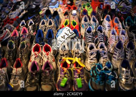 A participant number tag is seen among running shoes left at the makeshift memorial following the 2013 Boston Marathon bombings, in an exhibit titled 'Dear Boston: Messages from the Marathon Memorial' at the Boston Public Library in Boston, Massachusetts April 16, 2014.  The 118th running of the Boston Marathon will be held April 21.   REUTERS/Brian Snyder (UNITED STATES - Tags: SPORT ATHLETICS DISASTER CRIME LAW TPX IMAGES OF THE DAY)