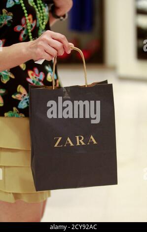 Una mujer tiene una bolsa de compras en una tienda Zara en el centro  comercial Siam Paragon en Bangkok 29 de junio de 2011. Mientras la música  pop se sonaba desde una