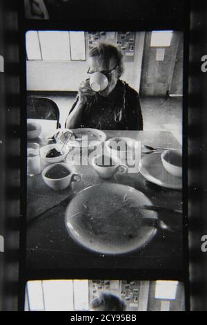 Fotografía en blanco y negro de la época de los años 70 de una anciana que disfruta de su almuerzo.