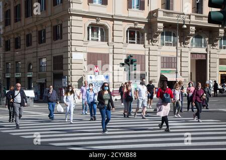 ROMA, ITALIA - OCTUBRE de 01 2020: Los usuarios de trabajo, con máscaras protectoras, cruzan una carretera en Roma, Italia. Foto de stock