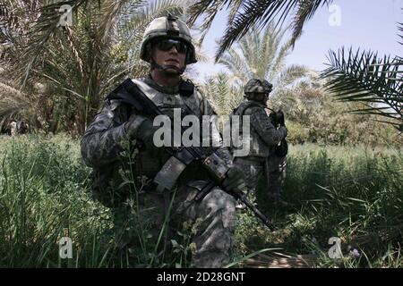 Los soldados estadounidenses toman posición durante una patrulla en Kerbala, a 80 km (50 millas) al sur de Bagdad el 17 de julio de 2010. REUTERS/Mushtaq Muhammed (IRAQ - Tags : - Tags: POLÍTICA MILITAR DE CONFLICTOS)