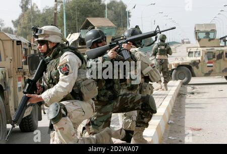 Iraqi soldiers take up position on a road during a patrol in Baghdad February 17, 2008. REUTERS/Mohammed Ameen  (IRAQ)