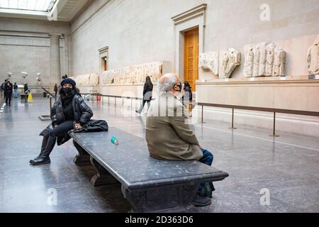 Dos figuras sentadas en el Museo Británico, Londres, Reino Unido. Elgin Marbles jinetes de friso de mármol en el lado norte de Parthenon Atenas cuarto siglo Foto de stock