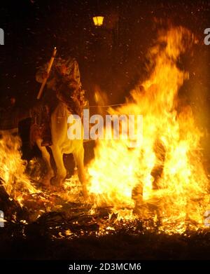 A rider encourages his horse through a bonfire during the annual Saint Anthony purification ceremony in the village of Vilanova d'Alcolea near Castellon,Spain, January 22, 2005. The festival coincides every year with the eve of the religious festivity of Saint Anthony, patron saint of animals, and according to pagan tradition of the winter solstice,denominated 'La Matxa', revellers ride their horses through bonfires placed around the village to purify the animals with fire after receiving a blessing from a priest. Picture taken late January 22, 2005. REUTERS/Gustau Nacarino  GN/AA