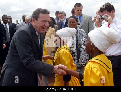 GERMAN CHANCELLOR GERHARD SCHOEDER SHAKES HANDS WITH SCHOOL CHILDREN AT THE STANZA BOPAPE COMMUNITY HEALTH CENTRE.  German Chancellor Gerhard Schroeder, shakes hands with residents during his visit at the Stanza Bopape Community Health and Development Centre in Mamelodi, a black township near Pretoria, January 23, 2004. Schroeder is on the third leg of a four-nation trip to Africa. REUTERS /Juda Ngwenya