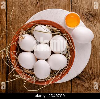 Huevos de pollo blancos en un Bol sobre una mesa de madera. Vista superior.