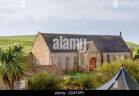 El granero grande del diezmo en las ruinas de la Abadía de Abbotsbury, un antiguo monasterio benedictino en Abbotsbury, Devon, al sureste de Inglaterra, visto desde Abbey House