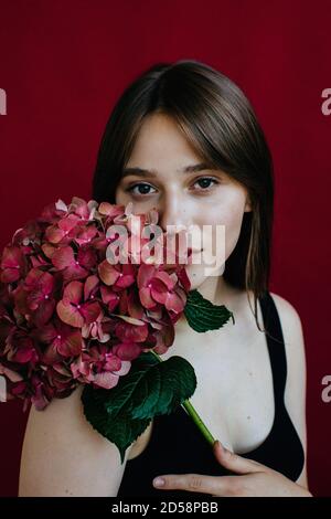 Retrato de una joven que sostiene una hidrangea