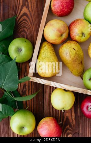 manzanas y peras en una bandeja sobre fondo de madera