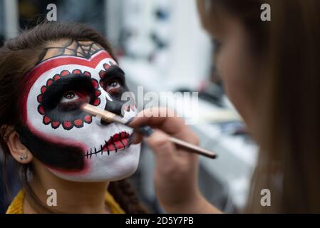 Maquillaje artista pinta la cara de una chica con pinturas para Halloween  Fotografía de stock - Alamy