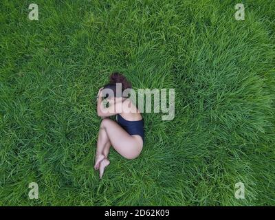 Mujer meditando en un campo de hierba vacío.