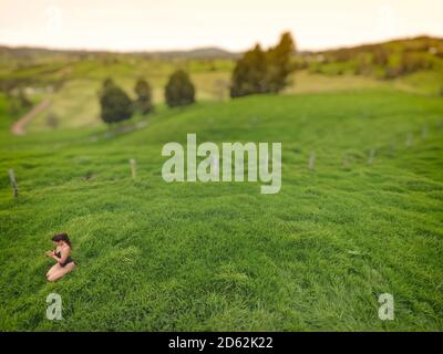 Mujer meditando en un campo de hierba vacío.