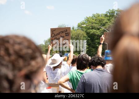El manifestante que sostiene su queerness no absuelve su señal del racismo durante protesta, Brooklyn, Nueva York, EE.UU.