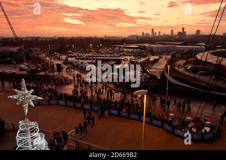 Los aficionados llegan al estadio Etihad mientras el sol se pone antes del partido Foto de stock