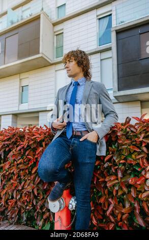 Hombre con elegante ropa formal y con bolsa está fuera contra el edificio  moderno Fotografía de stock - Alamy