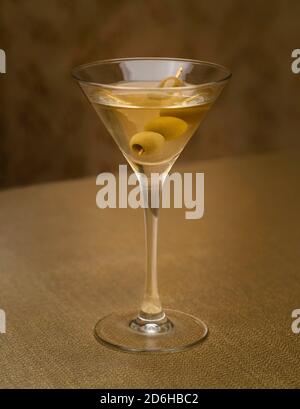martini vodka con aceitunas en el interior sobre tejido dorado