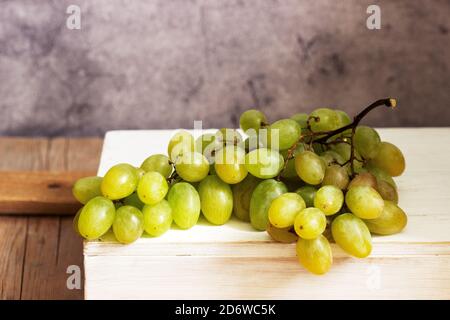 Racimos de uvas de color ámbar sobre un fondo de hormigón gris. Foto de stock
