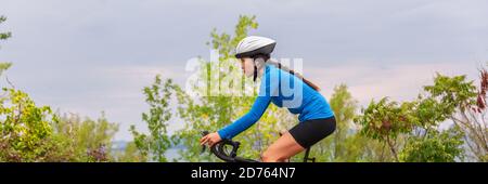 Mujer en bicicleta fuera de montar en bicicleta en verano al aire libre fondo panorámico encabezado Foto de stock