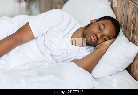 Deprimido Negro Guy Lying teniendo Insomnia en el dormitorio en casa Foto de stock