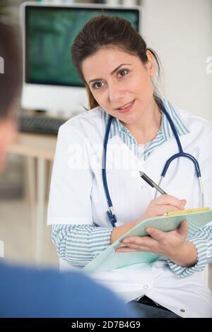 la doctora llena el formulario médico en el portapapeles Foto de stock