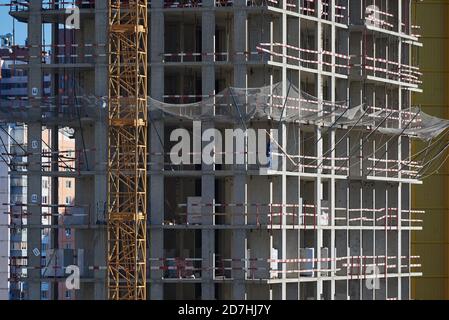 Un trabajador instala redes de seguridad en un lugar de construcción Foto de stock