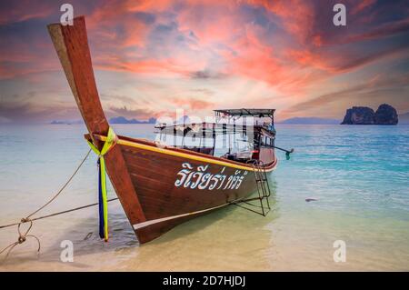 Increíble puesta de sol sobre el barco de cola larga en la playa en Tailandia Foto de stock