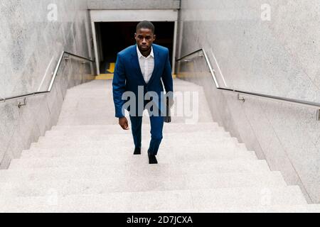 Hombre de negocios subiendo por la escalera en el metro de la ciudad Foto de stock
