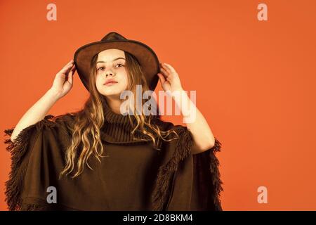 Alma occidental. Vaquero sombrero adorable chica. Ropa americana. Cultura  de rancho. Tradiciones occidentales. Elegante confianza niña adolescente  frío con sombrero y poncho. Concepto de estilo de moda. Oeste salvaje. Niño  occidental Fotografía